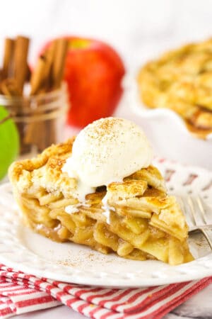 A slice of apple pie with vanilla ice cream on top.