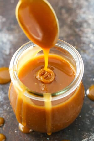 Drizzling caramel sauce into a jar full of it.